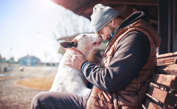 額を寄せる男性と犬