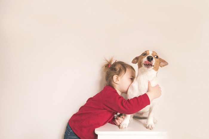 急に子供に抱きつかれて驚く犬