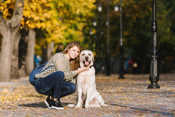 犬としゃがんでいる女性