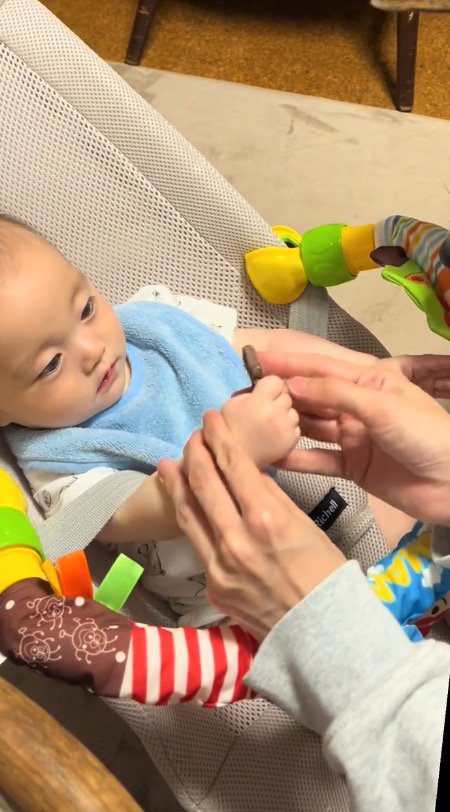 おやつを持っている赤ちゃんの手を優しく支える飼い主