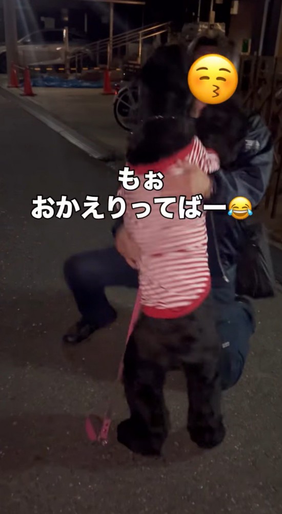 黒い犬の前にしゃがむ男性