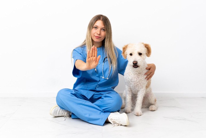 手を出す女性と犬