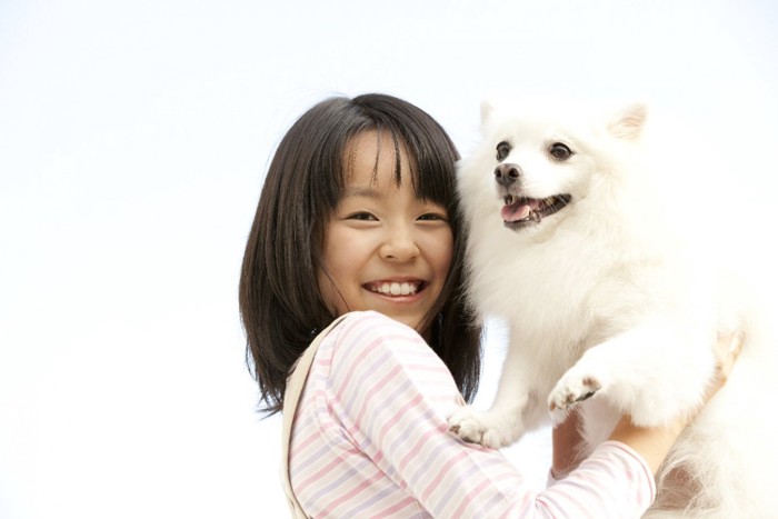 犬を抱っこしている子ども