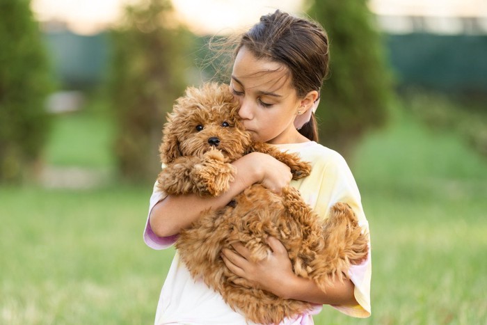 少女に抱っこされる犬