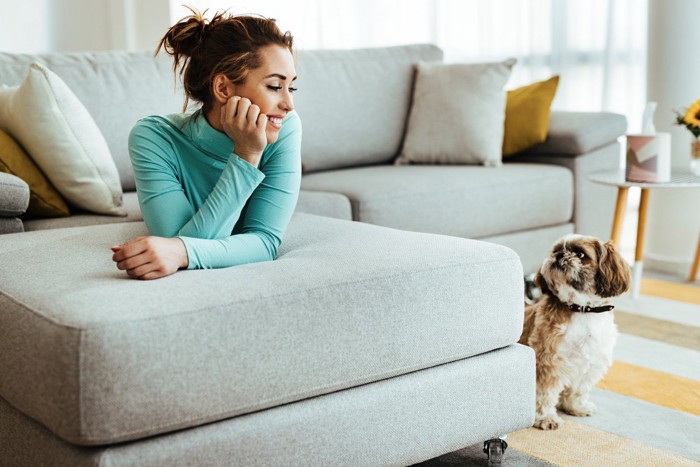 笑顔でみつめる女性と懐疑的な表情の犬