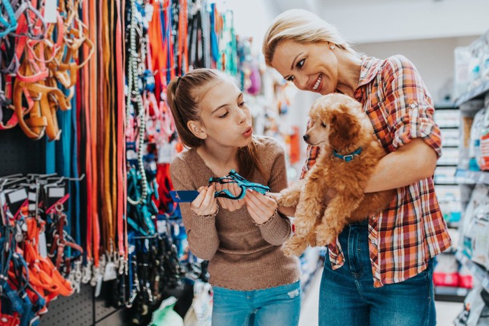 愛犬を連れて買い物をする女性の親子