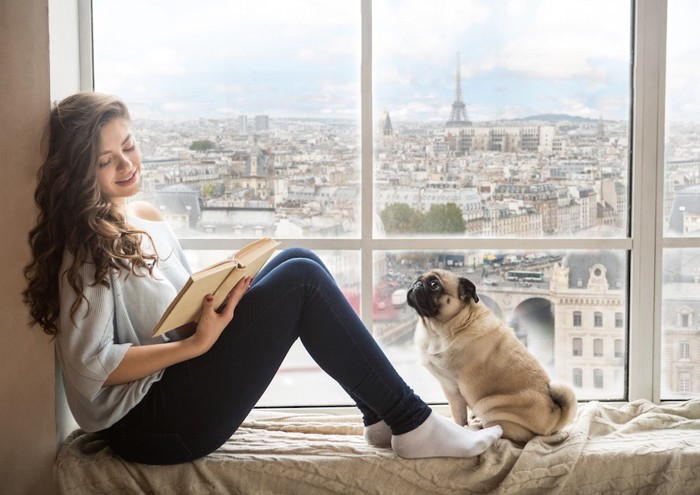 窓辺の女性と犬