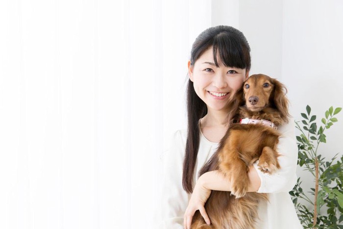 犬を抱いている女性