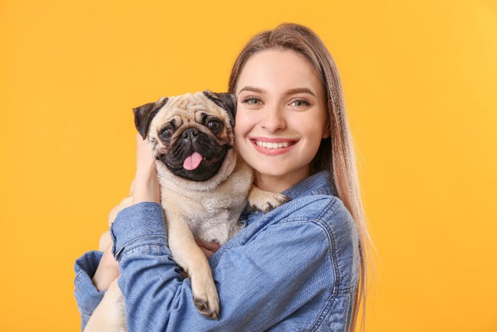 犬を抱っこする笑顔の飼い主