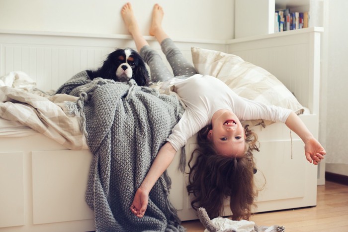 ベッドで遊ぶ女の子と犬