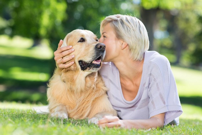 犬の頭にキスをする女性