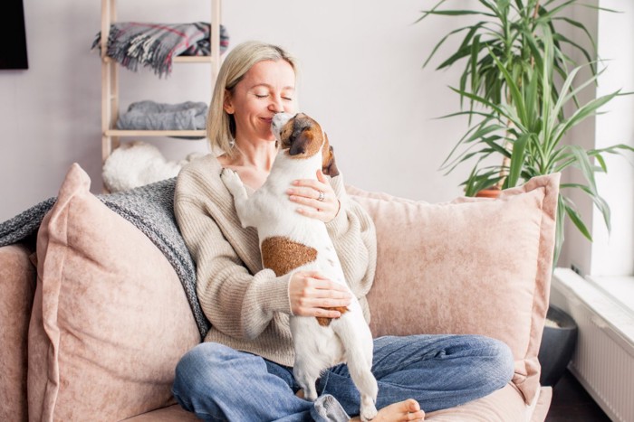 女性の顔を舐める犬