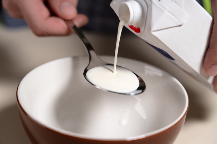 生クリームをスプーンに注いで計量している光景