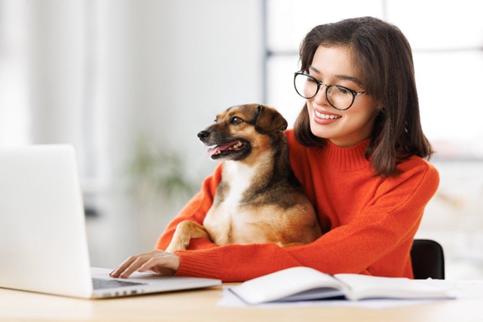 犬といっしょにパソコンに向かう女性