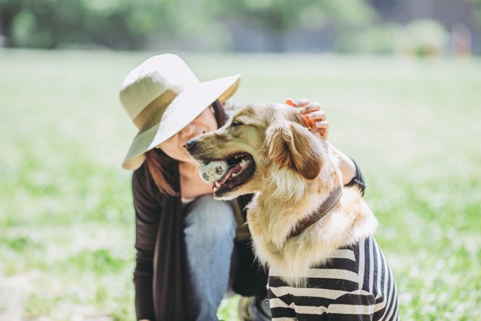 ボールを咥えた犬と女性