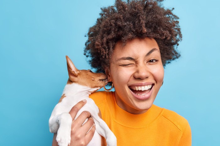 女性の耳を舐める犬