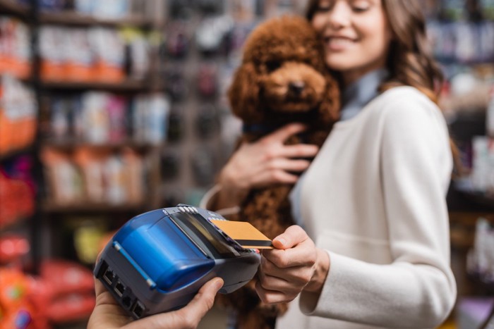 愛犬を抱いて買い物する女性