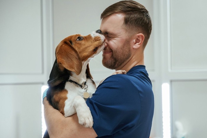 男性の顔を舐める犬