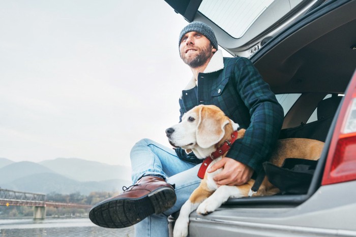 車で休憩中の犬と男性