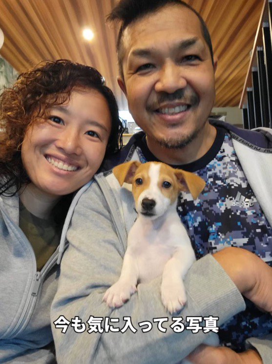 犬を囲んで笑顔で写真を撮る家族