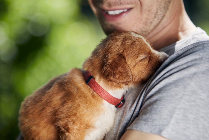 子犬を抱く男性