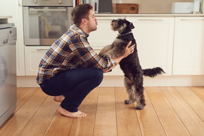 立ち上がる犬を支える人