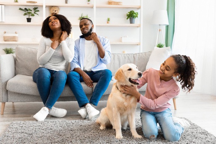 痒がる男女と子供と犬