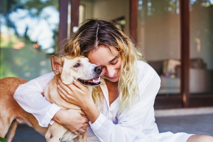 愛犬とスキンシップをとる女性