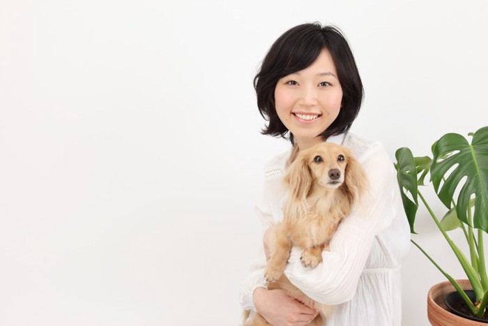 抱っこされる犬と女性