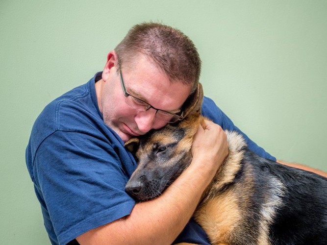 犬を抱きしめる男性