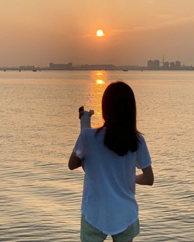 犬を抱っこする女性の後ろ姿