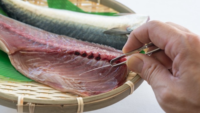 サバの切り身から骨を取っている様子