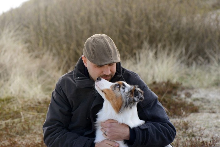 犬を抱く男性