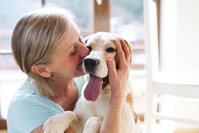 愛犬にキスをするシニア女性