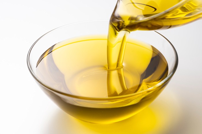 ガラスの器に油を注いでいる光景