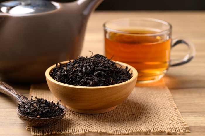 木の器とスプーンに盛られた紅茶の茶葉