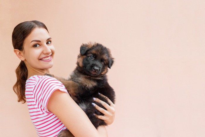 女性に抱っこされる犬