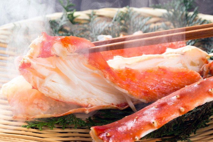 火を通したカニの身をお箸で持ち上げている様子