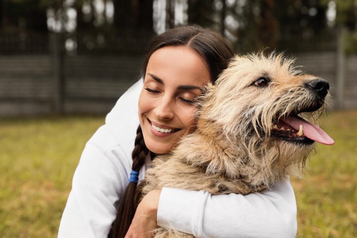 女性にハグされている犬