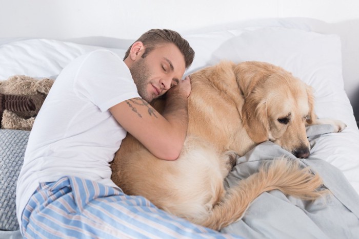 犬の背中で眠る男性