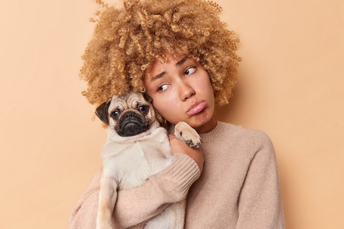 犬を腕に抱っこする女性