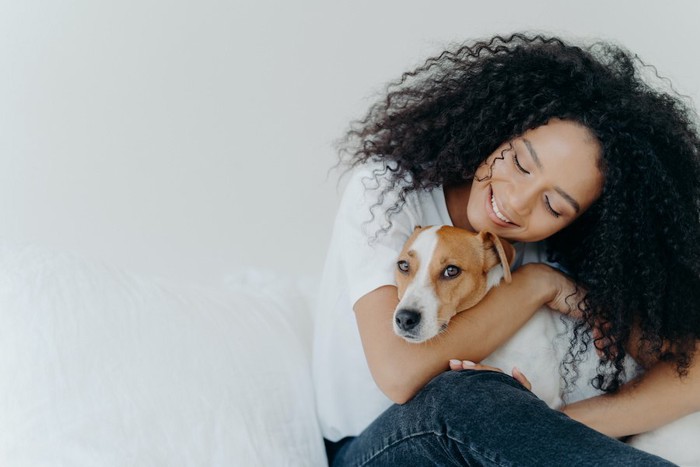 笑顔で犬を抱きしめる女性