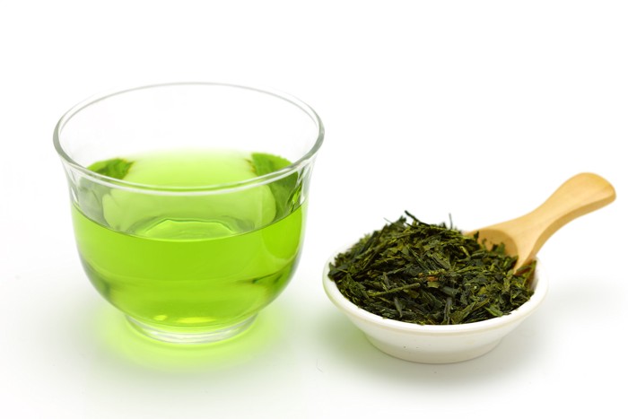 ガラスの器に入った緑茶とお皿にも盛られた茶葉